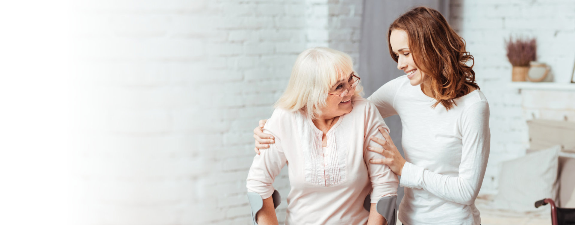 adult woman helping a senior woman walk